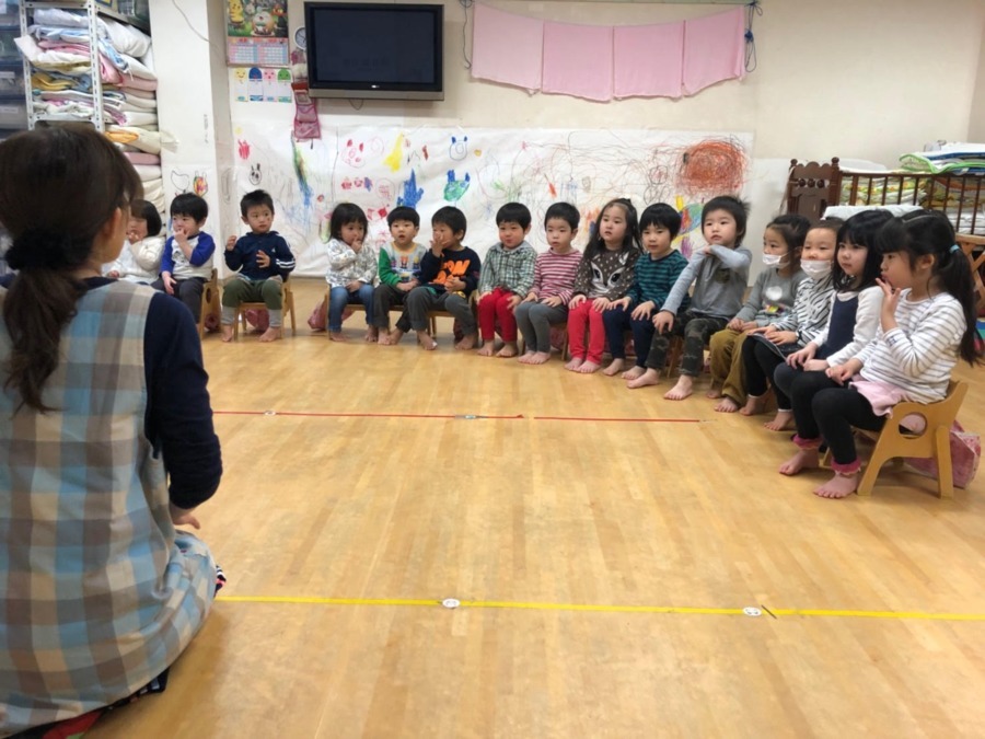 保育園あっぷるキッズ青戸園の写真3枚目：朝の会の一コマ。先生が「昨日の嬉しかったこと」を園児達に話しているところです。