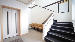 たけだ皮膚科スキンケアクリニックの写真2枚目：入口エントランスからすぐ、2階美容フロアへ続く階段と専用エレベーター