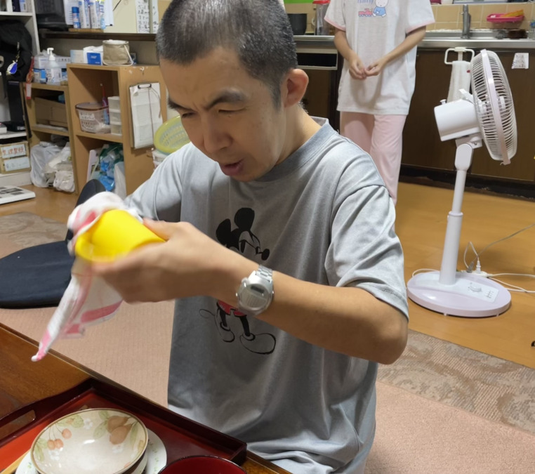 ケアホームひまわり 第一ひまわり（生活支援員の求人）の写真3枚目：利用者さんが食器拭きをしています：その人に合った活動を支援します