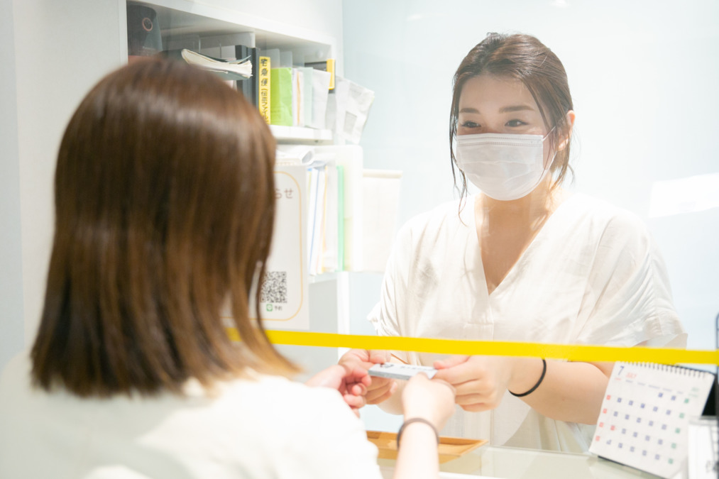 榎本歯科医院（歯科助手の求人）の写真2枚目：＜受付＞
患者さまには、にこやかに丁寧な対応を心がけています。