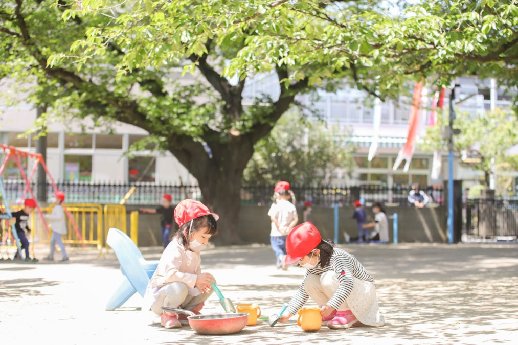 ひばり幼稚園の写真3枚目：気持ちの良い園庭で、おままごと。この後、輪が広がり大家族ごっこになりました。