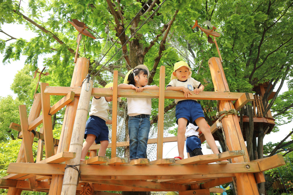 東江幼稚園（幼稚園教諭の求人）の写真5枚目：緑豊かな園庭で,身体を使って遊んでいます。
