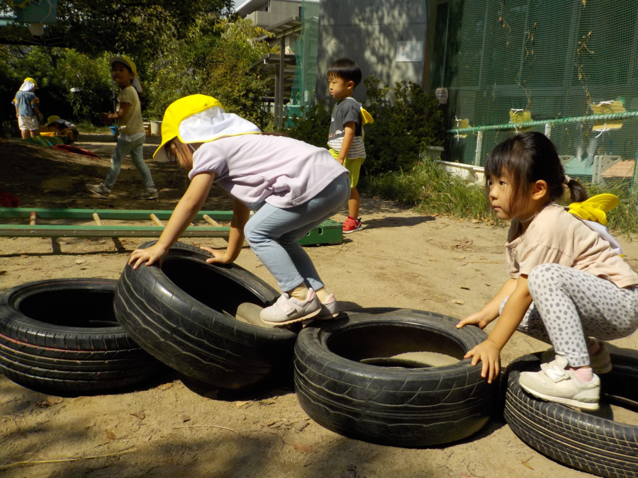 幼保連携型認定こども園 ニコニコ桜保育園（保育士の求人）の写真24枚目：タイヤをつなげて、上手に渡れるかな？