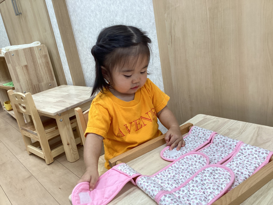 アベニール保育園（保育士の求人）の写真6枚目：日常生活の練習でマジックテープの付け外しに挑戦中！