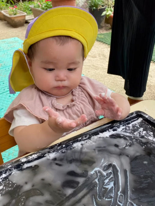 神田保育園（保育士の求人）の写真5枚目：片栗粉で感触あそび🤭　０歳児です✨　触りたくない子も興味津々な子も様々❣️ 