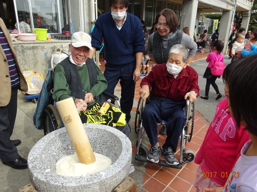 グループホームてぃだの家うちまの写真8枚目：正月に自治会で餅つき大会に参加中。