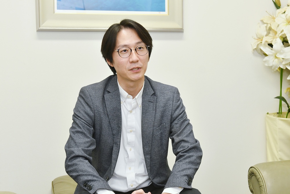 インタビューにこたえる塚越さん