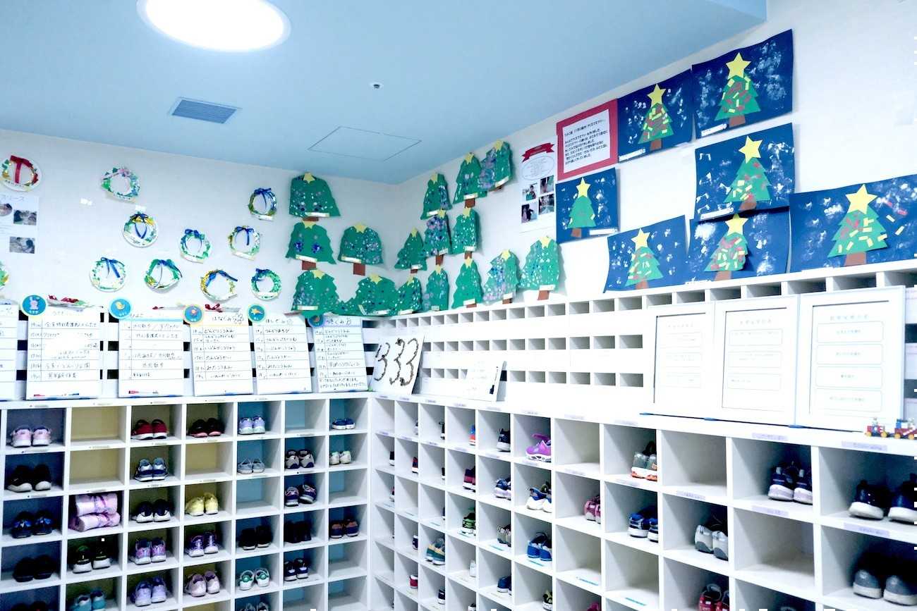 花房山目黒駅前保育園333の入り口の棚や壁に子どもたちの作品が飾ってある様子