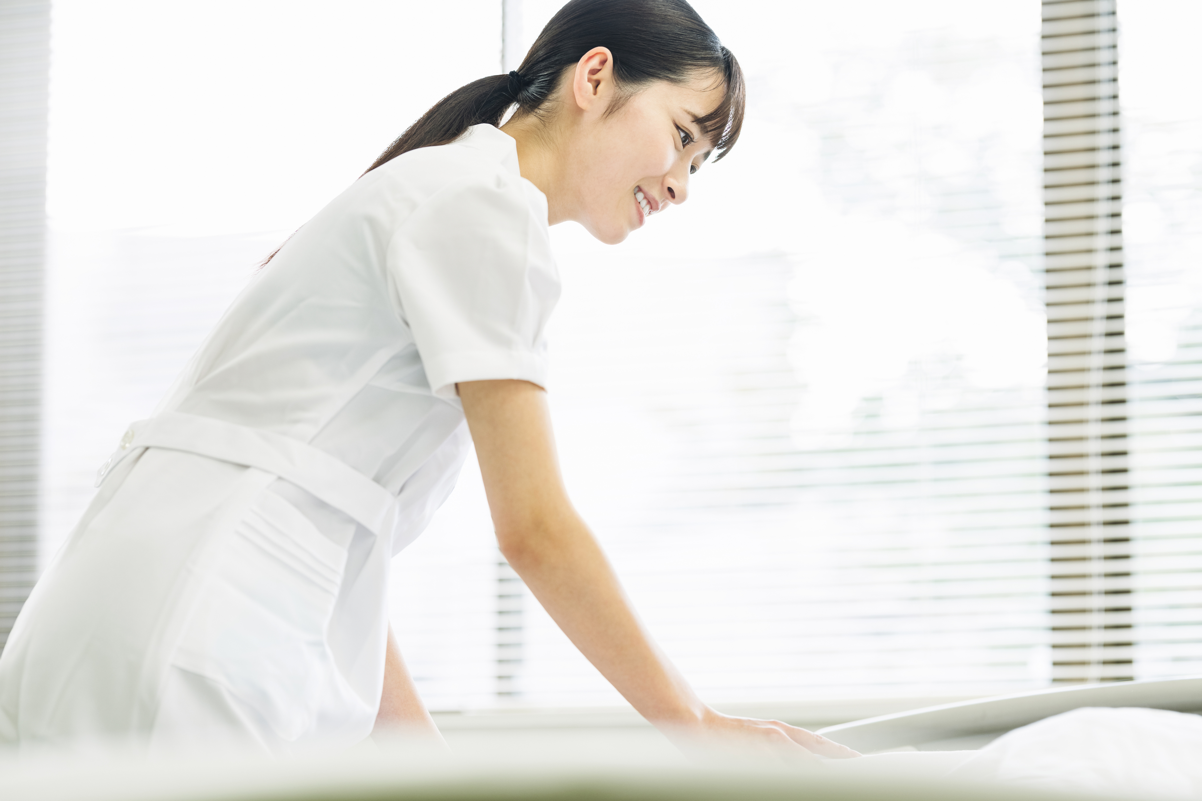 看護師の女性が職場での仕事に励んでいる様子。